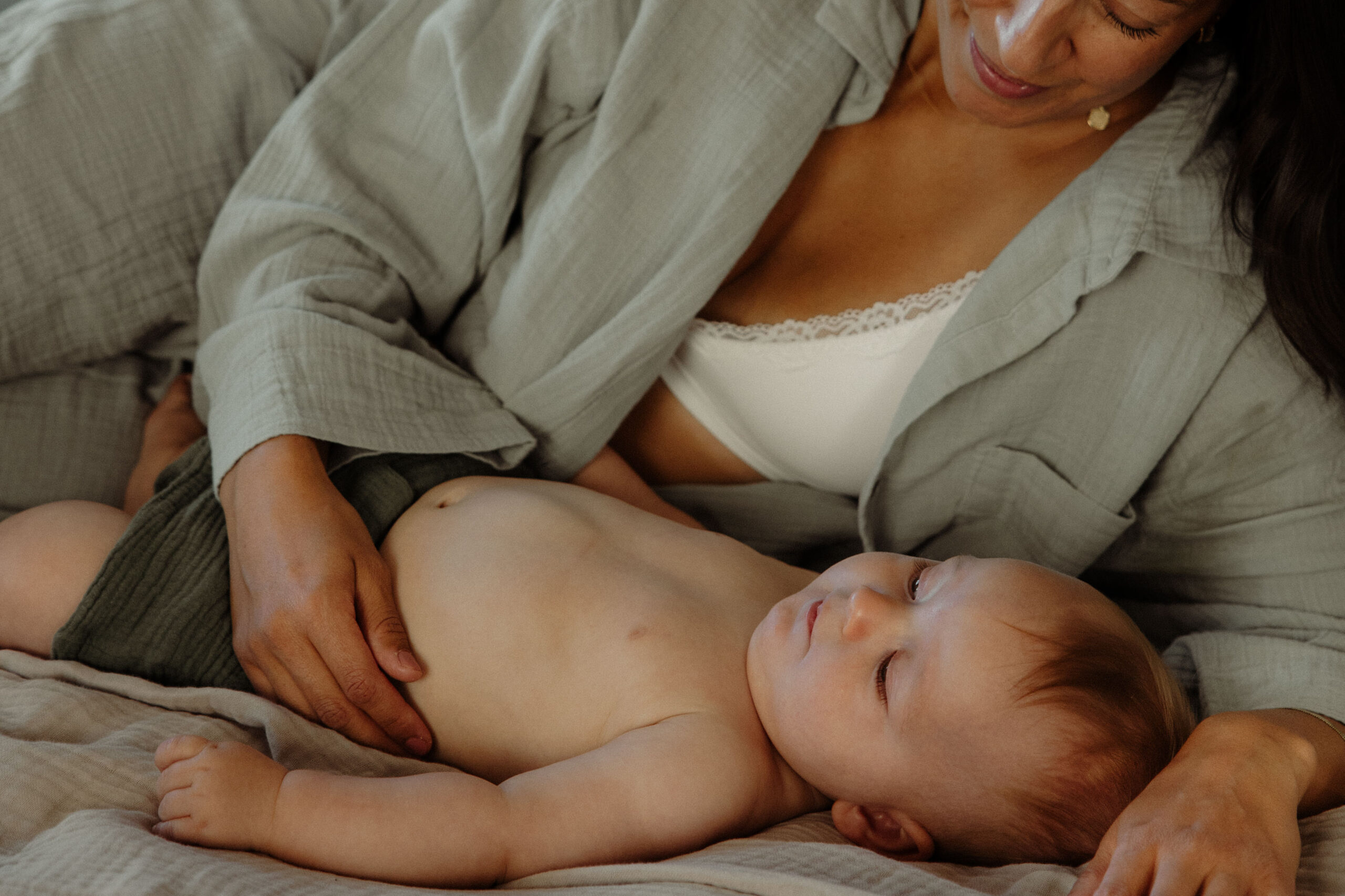 en mamma och hennes bebis ligger i sängen och myser