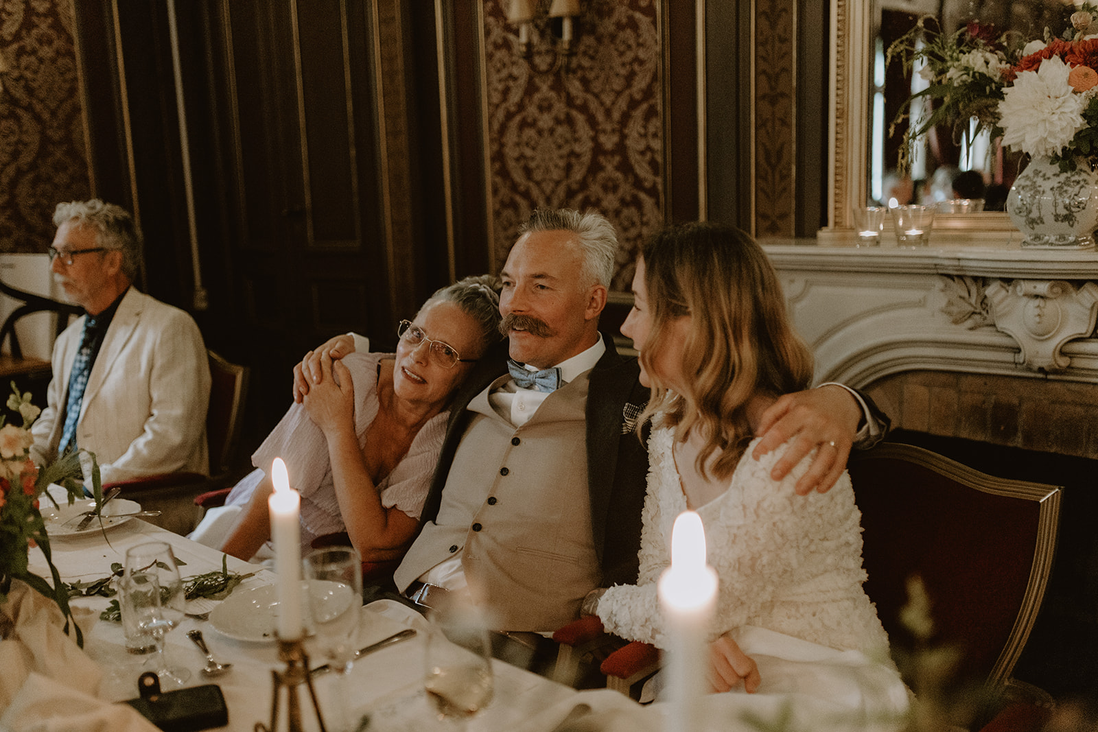 brudgum kramar om sin fru och mamma vid honörsbordet