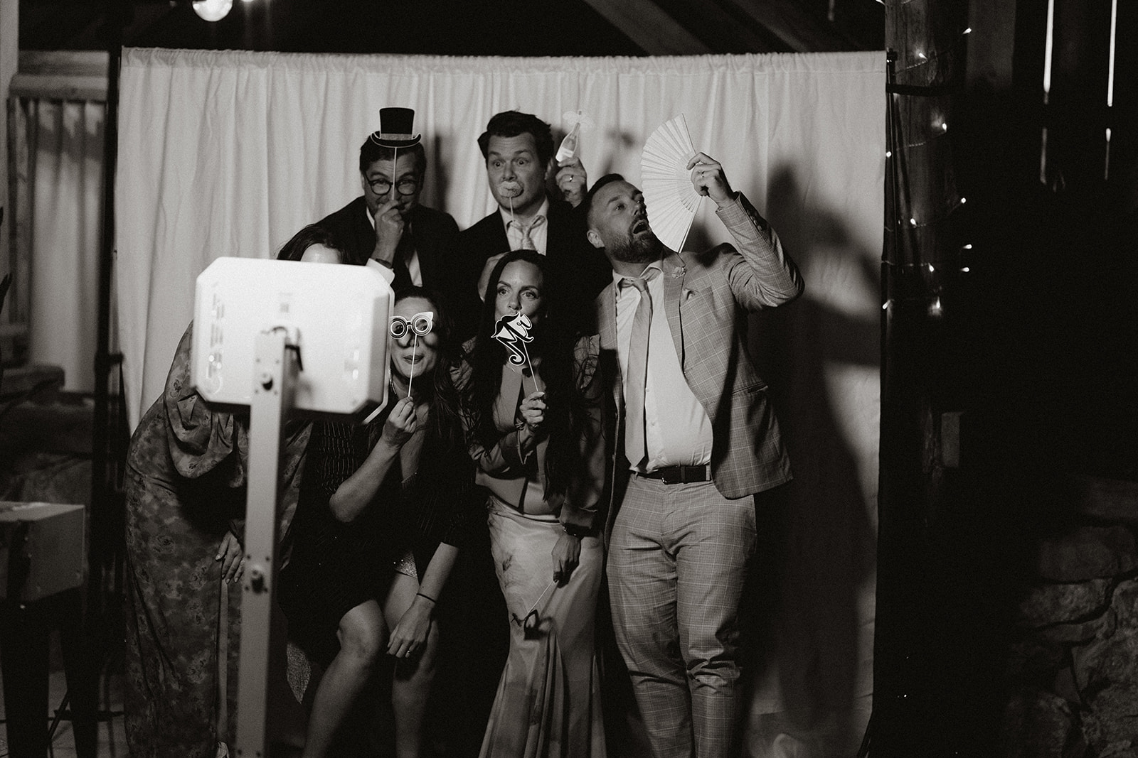 bröllopsgäster gör roliga charader framför ett photobooth