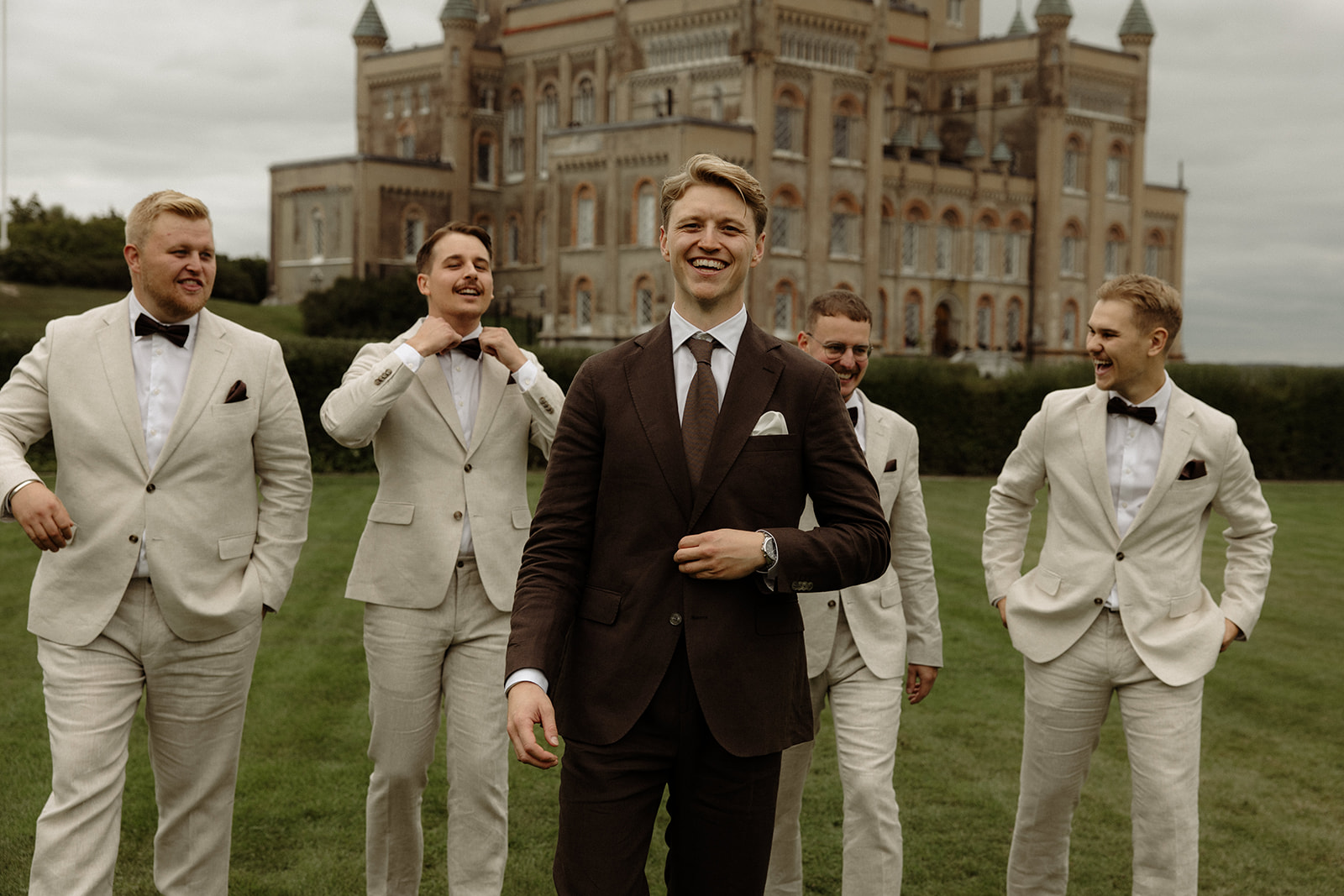 brudgum med sina bestmans gåendes framför ett slott
